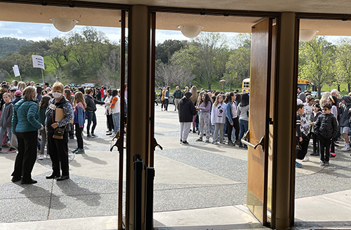 photo through concert hall doors of kids lining up for Symphony Day